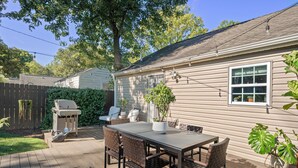 A patio with a table and chairs, a barbecue grill, and potted plants. - Bright & Stylish Home near Uptown - 3BR 2B + Outdoor (Charlotte)