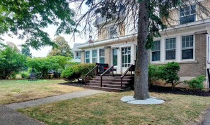 A two-story house with a front porch, a staircase, and a well-maintained lawn.