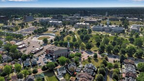 An aerial view of a campus with multiple buildings, parking areas, and green spaces.