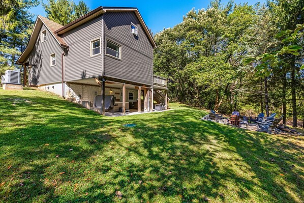 A two-story house with a covered porch and a grassy yard.