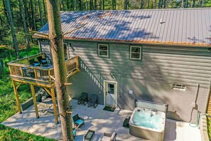 Una cabaña con terraza, mobiliario exterior y un jacuzzi.