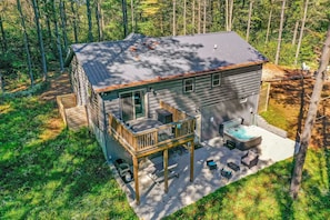 Een chalet met twee verdiepingen, een terras, een hottub en buiten zitplaatsen.