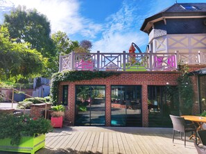 A patio area with a brick wall, glass doors, and outdoor seating.