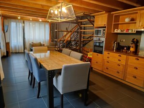 Una cocina moderna con armarios de madera, microondas integrado y cafetera.