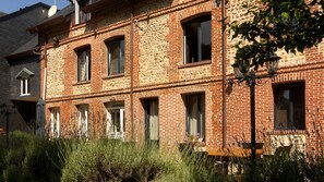 A multi-story brick building with several windows and a stone facade.