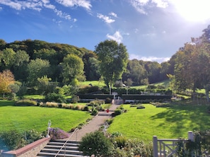 Un jardin bien entretenu, avec un chemin menant à un espace aménagé pour s’asseoir.