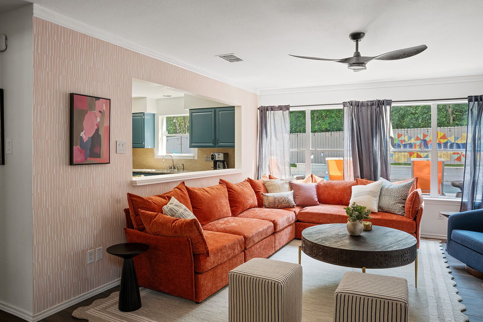 A living room with a sectional sofa, a round coffee table, and a blue armchair.