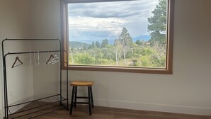 A room with a large window, a metal drying rack, and a wooden stool. - Cozy studio in charming Ridgway, CO (Ridgway)