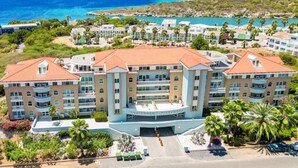A beachfront hotel with multiple balconies, a central entrance, and a view of the ocean. - Curacao,Piscadera Bay, next to Marriott, Very luxuriously furnished Apartment (Willemstad)