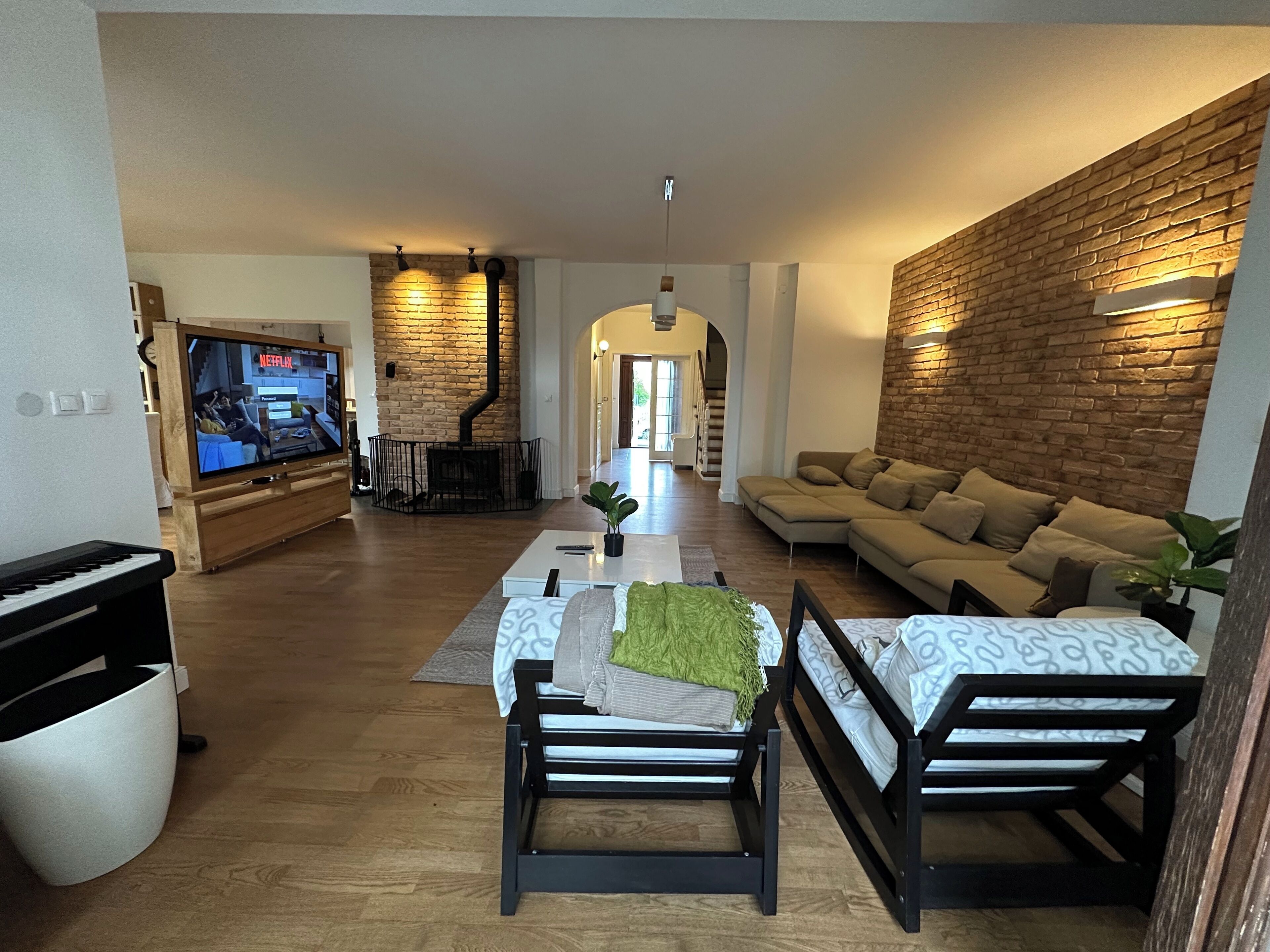 A living room with a fireplace, sofa, and TV.