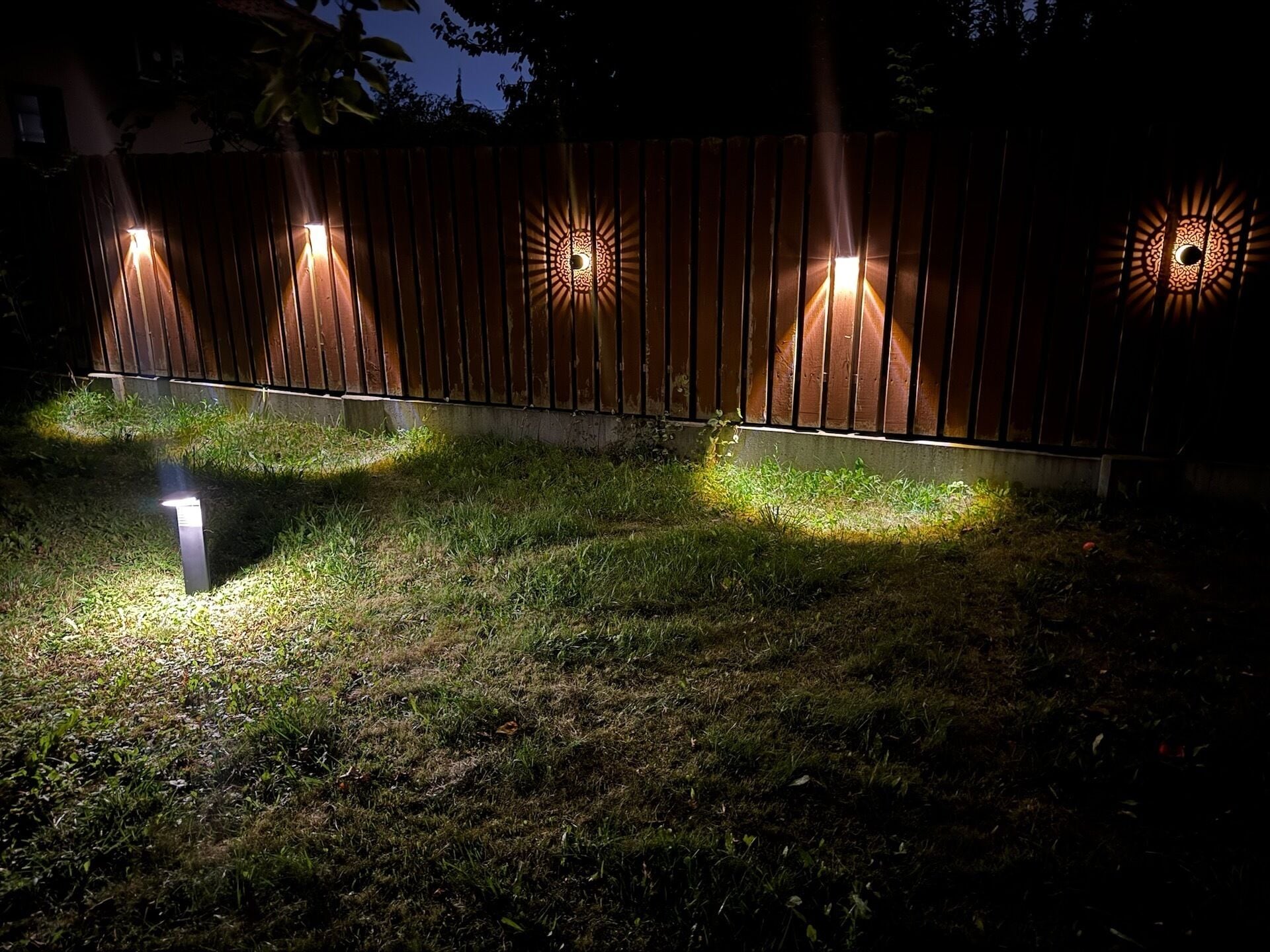 A wooden fence with decorative lighting fixtures.
