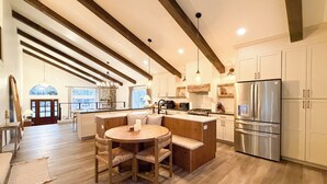 A spacious kitchen with a large island, wooden flooring, and modern appliances.