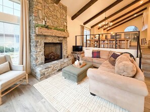 Una sala acogedora con chimenea de piedra, un sofá confortable y un comedor con muebles de madera.