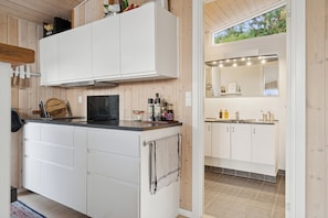 A modern kitchen with white cabinetry, a black countertop, and a visible stove.