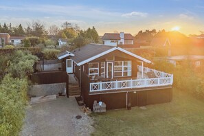 A two-story house with a deck, a garage, and a driveway. - Active coastal holiday in cozy cottage (Slagelse)