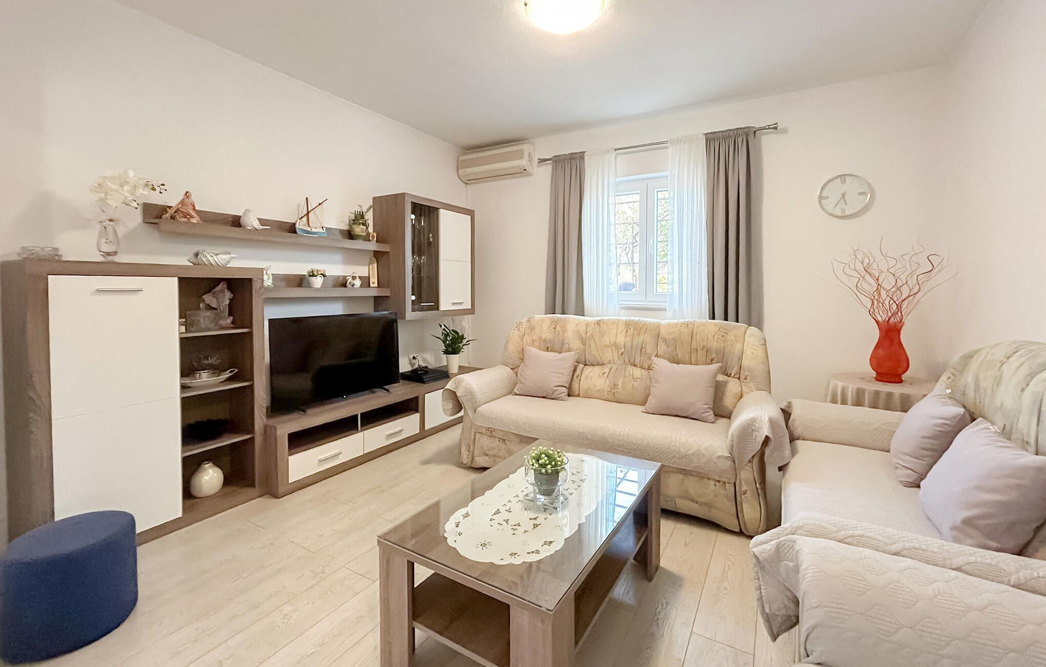 A living room with a sofa, a coffee table, a TV, and a cabinet.