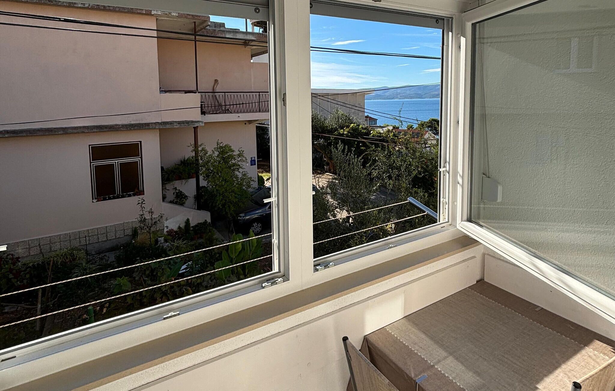 Un balcon donnant sur un quartier résidentiel et un plan d’eau.