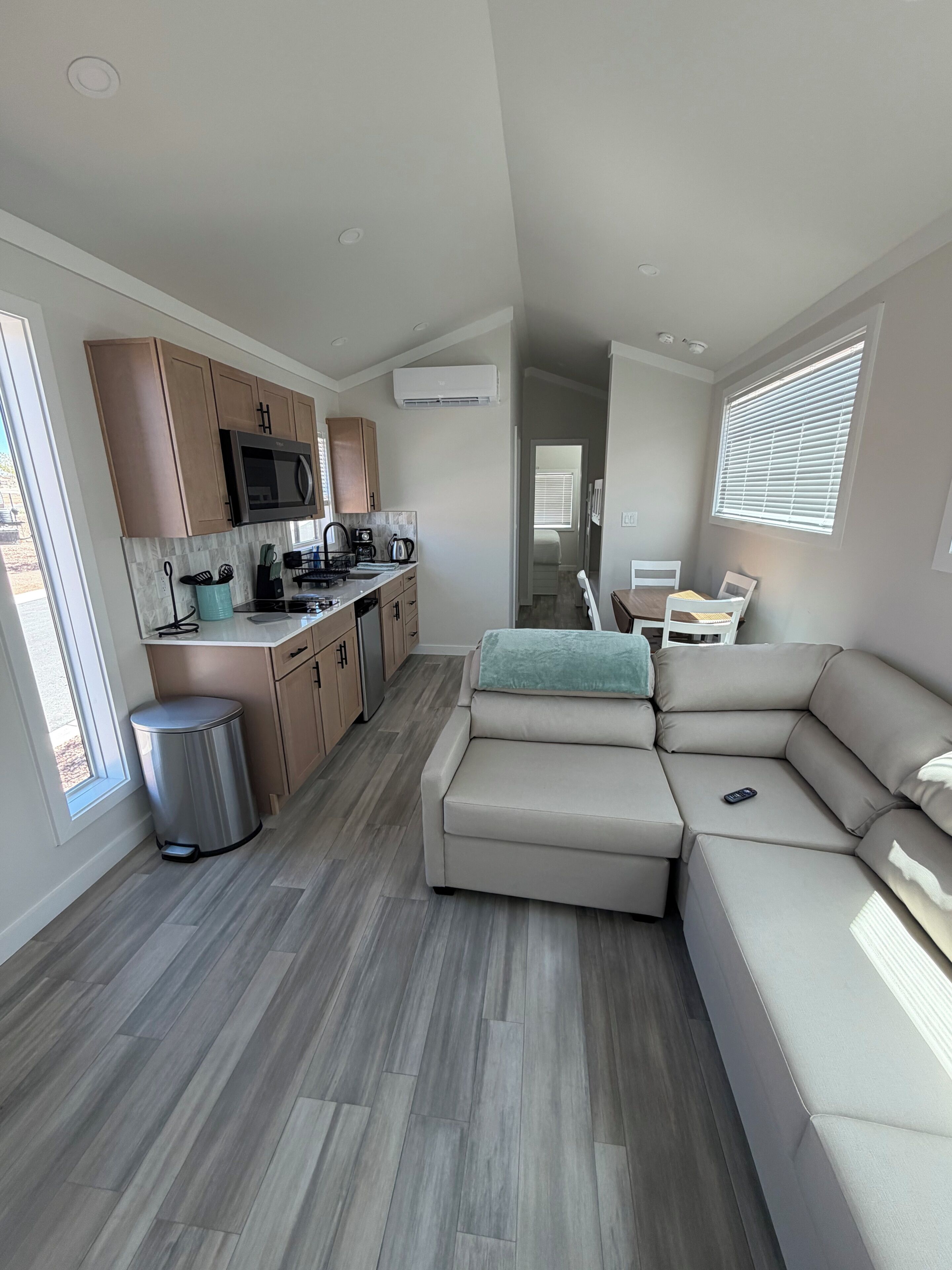 A modern kitchen with built-in appliances and a dining area with a sofa and table.