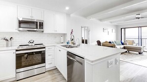 Een moderne keuken met witte kasten, roestvrijstalen apparatuur en een centraal eiland.