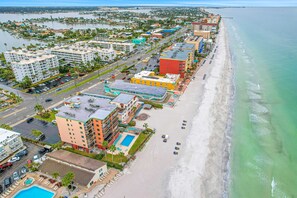 A coastal hotel with multiple buildings, a beach, and a marina. - Beachfront studio with grilling area and shuffleboard steps to sand (North Redington Beach)