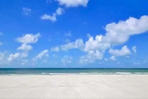 A beach with a clear sky and calm sea.