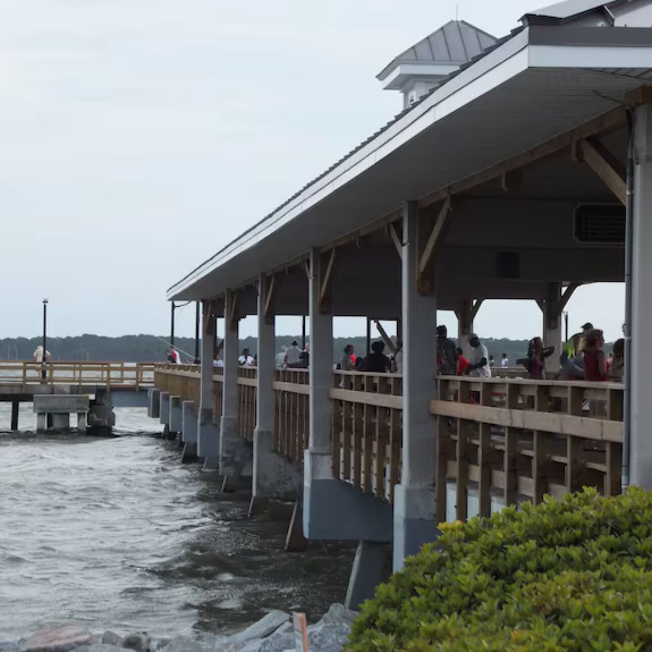 A pier with a covered seating area overlooking a body of water.