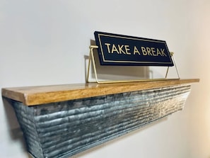 Ein Regal mit einem Schild, auf dem 'TAKE A BREAK' steht.
