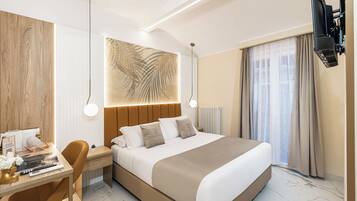 A modern hotel room with a large bed, a desk with a chair, a television, and a large window with curtains.