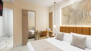 Ein Hotelzimmer mit einem großen Bett, einem Schreibtisch, einem Stuhl und einer großflächigen Wandmalerei.
