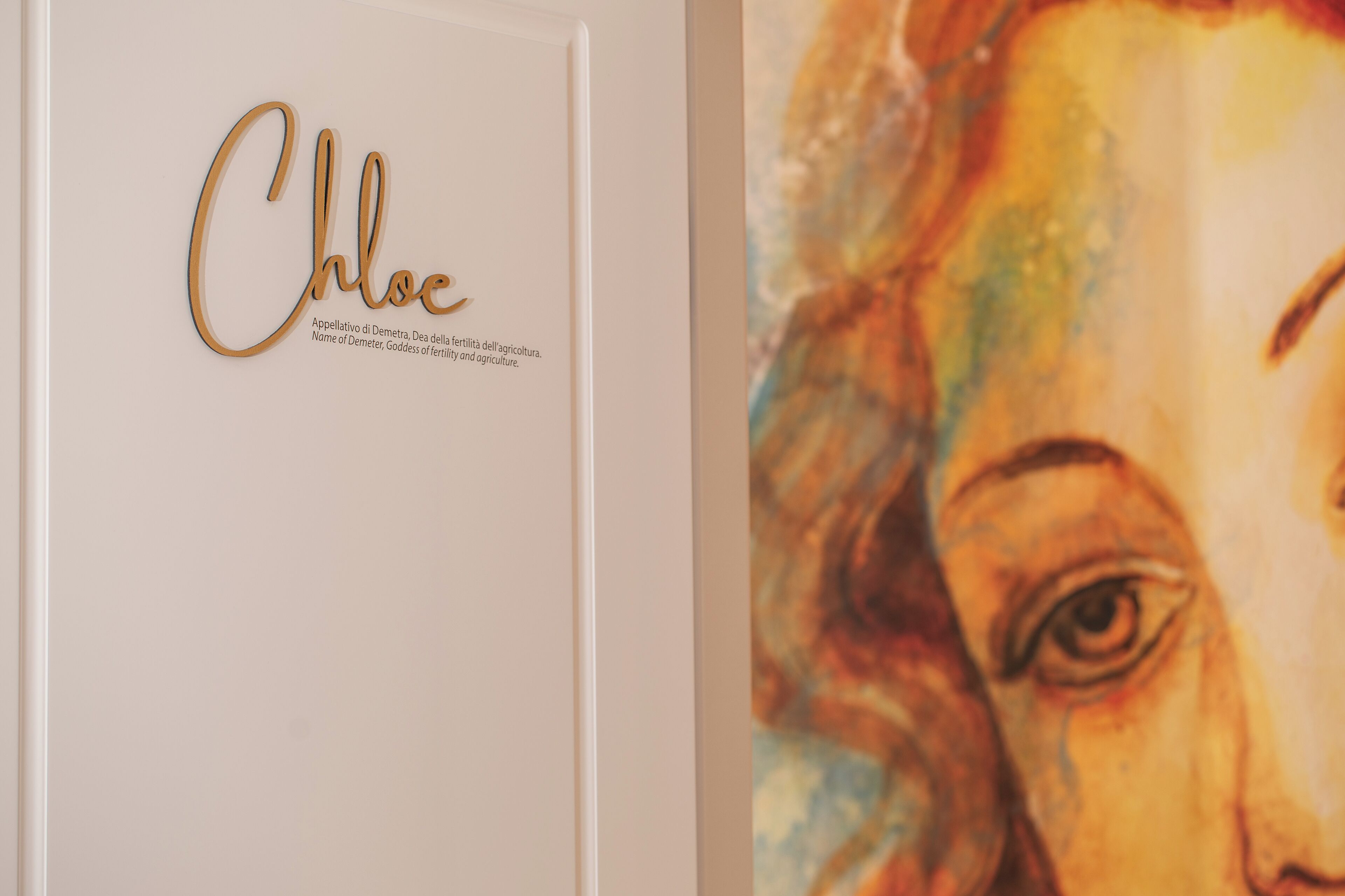 A wall with a nameplate and a partial view of a painting.