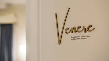 Een muur met de naam 'Venere' en de tekst 'Dea dell'amore e della bellezza Godin van liefde en schoonheid' in gouden letters.