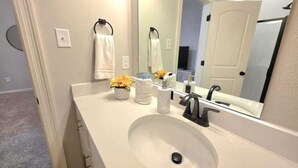 A bathroom with a white sink, a mirror, and a towel rack. - The Tigers Pathway House near LSU Stadium - BC1034 (Baton Rouge)