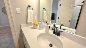 A bathroom with a white sink, a mirror, and a towel rack. - The Tigers Pathway House near LSU Stadium - BC1034 (Baton Rouge)