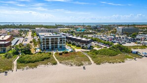 Ein Küstenhotel mit mehreren Gebäuden, einem Parkplatz und einem Strand im Vordergrund.