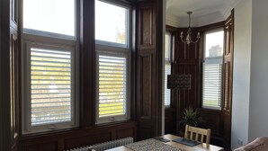A dining area with a wooden table, chairs, and a radiator.
