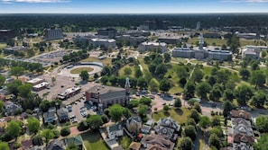 Vue aérienne d’un campus universitaire comprenant plusieurs bâtiments, des aires de stationnement et des espaces verts.