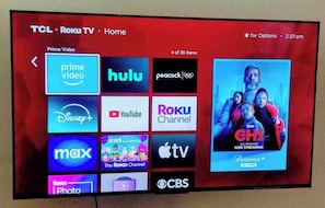 Un téléviseur TCL Roku affichant divers services de diffusion en continu et une publicité pour Paramount+.