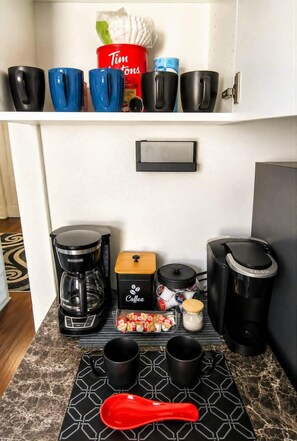 A kitchenette with a coffee maker, a Keurig, a coffee grinder, and a coffee storage box. - The Buffalo Loft- 3BR Upstairs Apartment • Pet-Friendly • Outdoor Patio &... (Buffalo)