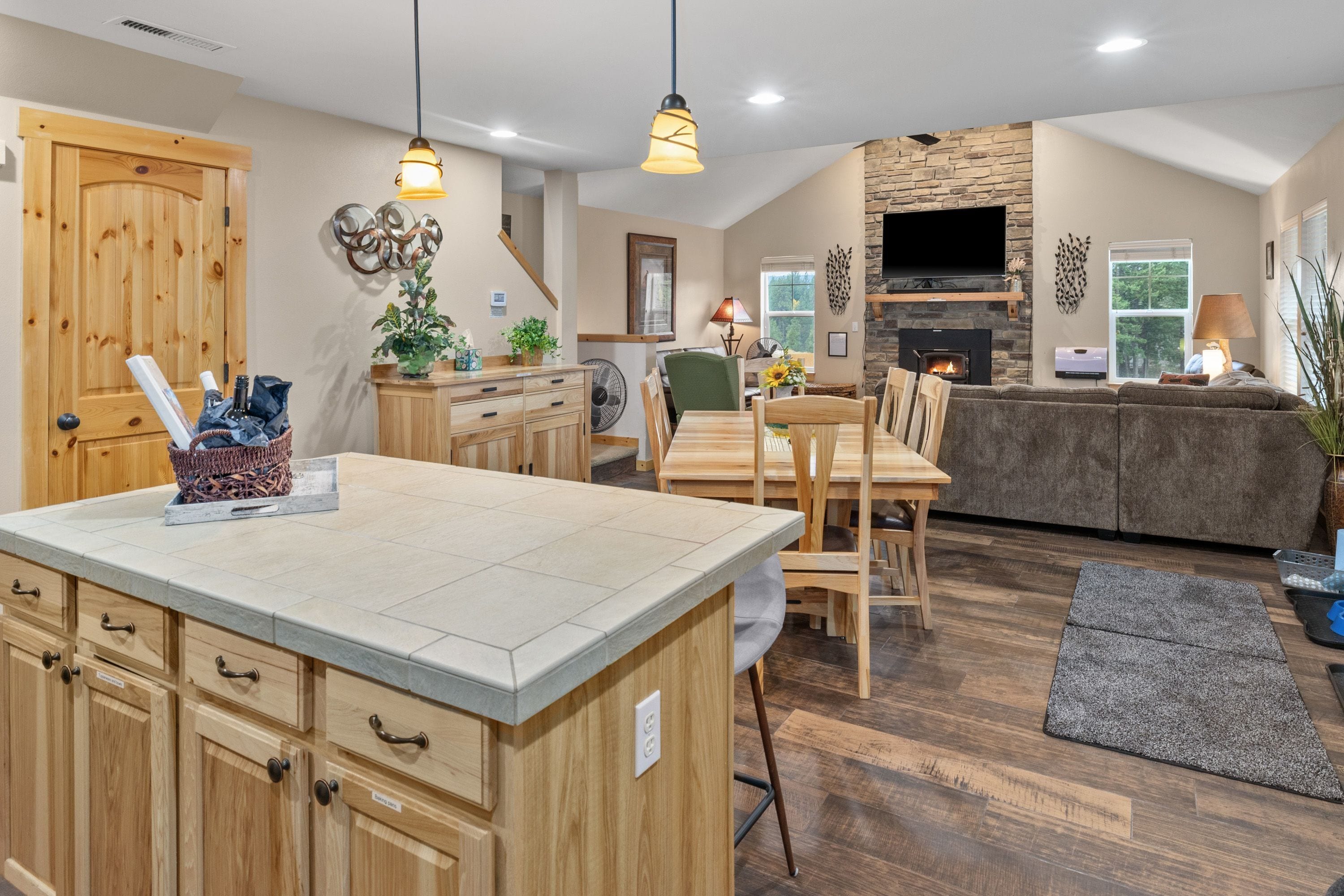 A spacious kitchen with wooden cabinetry, a central island, and a dining area with a table and chairs.