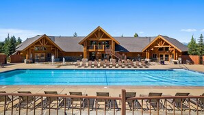 A lodge with a large pool, outdoor seating, and a mountain backdrop. - Raintree at Roslyn Ridge - Cozy Retreat (Ronald)