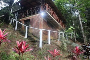 Un edificio rustico in legno con una scala che conduce a un balcone.