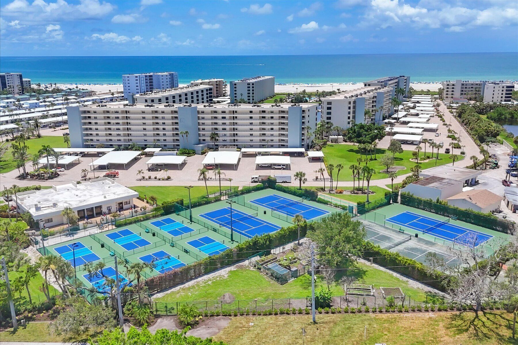 A resort with multiple tennis courts, a pool, and beachfront views.