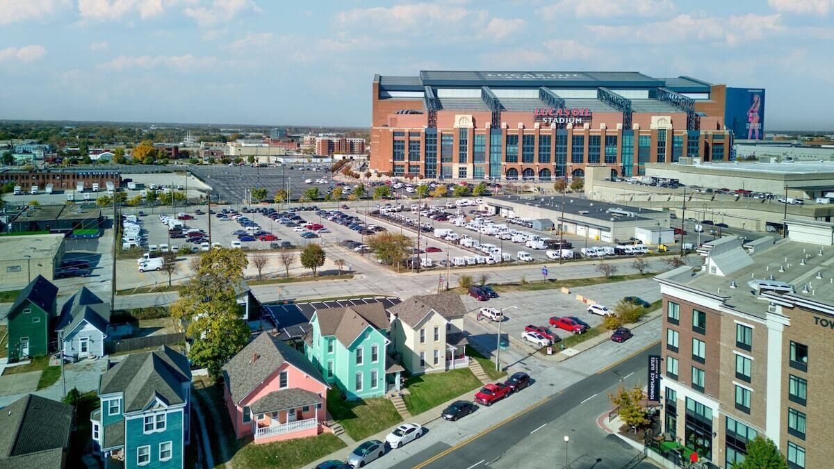 Un grand stade avec un parking situé devant.