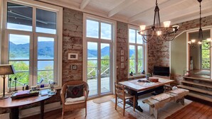 A spacious room with large windows offering a scenic view of mountains and a lake. - Awesome home in Vaksdal with house sea view (Vaksdal)