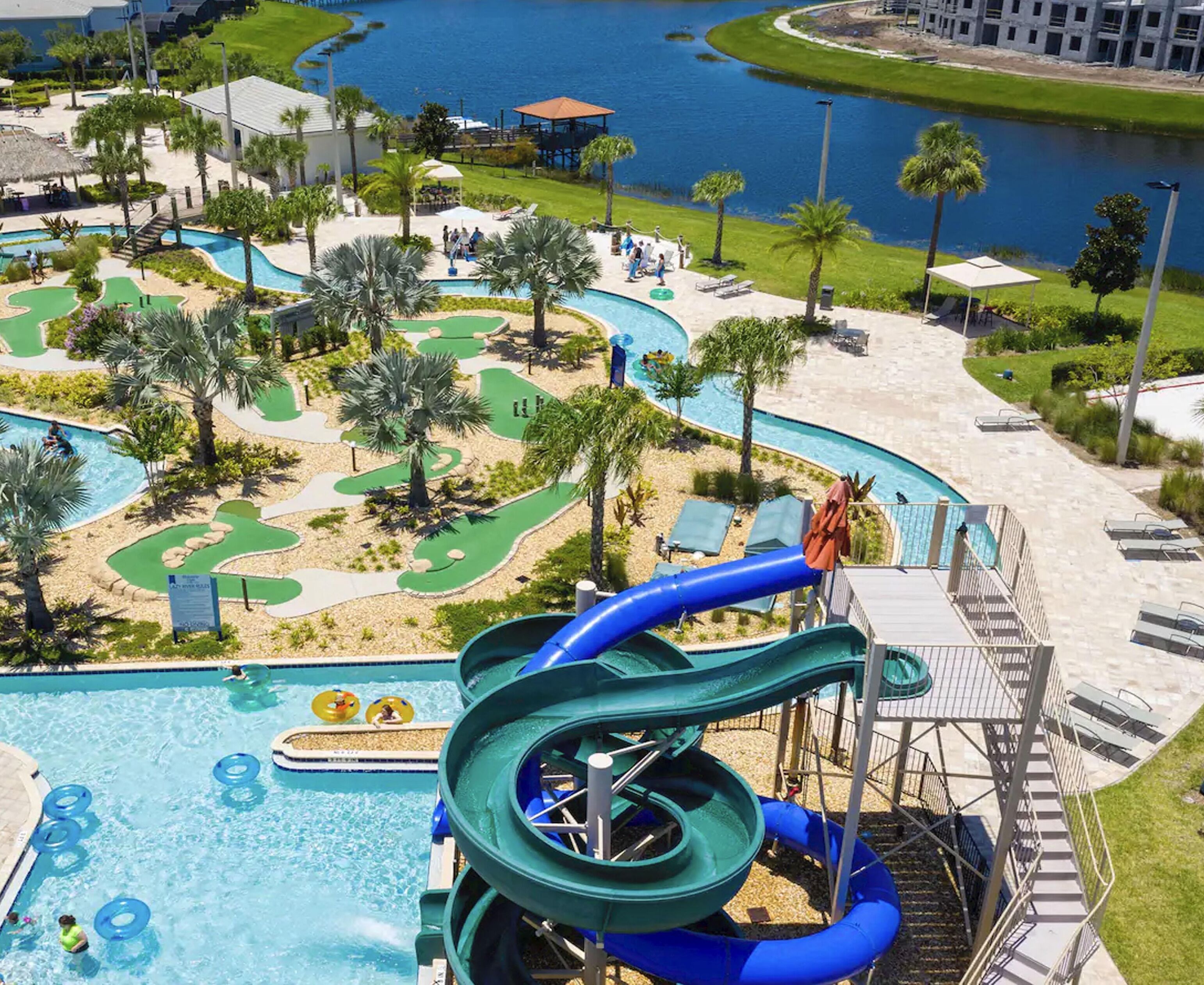 A resort with a large pool, water slides, and a golf course.