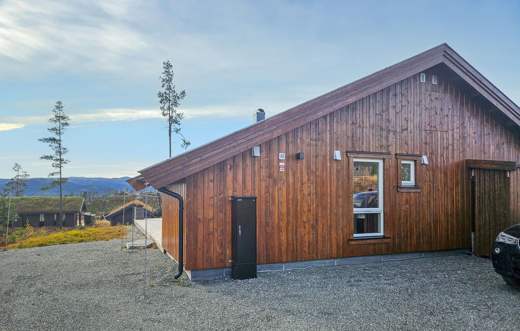 A wooden cabin with a sloped roof, a small window, and a door.