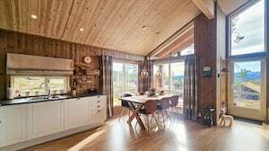 A spacious kitchen with wooden cabinets, a large window, and a dining area with a table and chairs. - 3 bedroom awesome home in Flå (Flå)