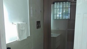 A small bathroom with a toilet, sink, and shower.