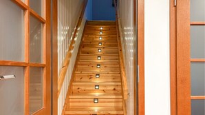 A wooden staircase with multiple steps, each with a small light fixture.