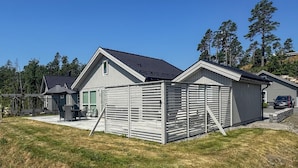 A modern house with a garage, a covered patio, and a lawn. - 4 bedroom awesome home in Færvik (Færvik)